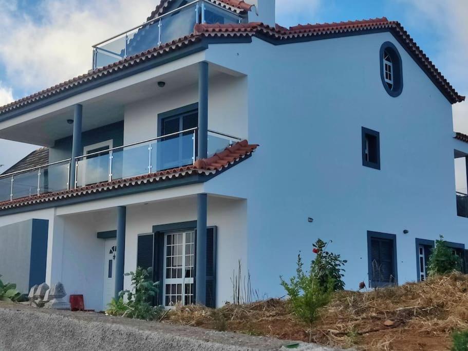 a white house with a balcony on top of it at Casa Neto Jardim in Calheta