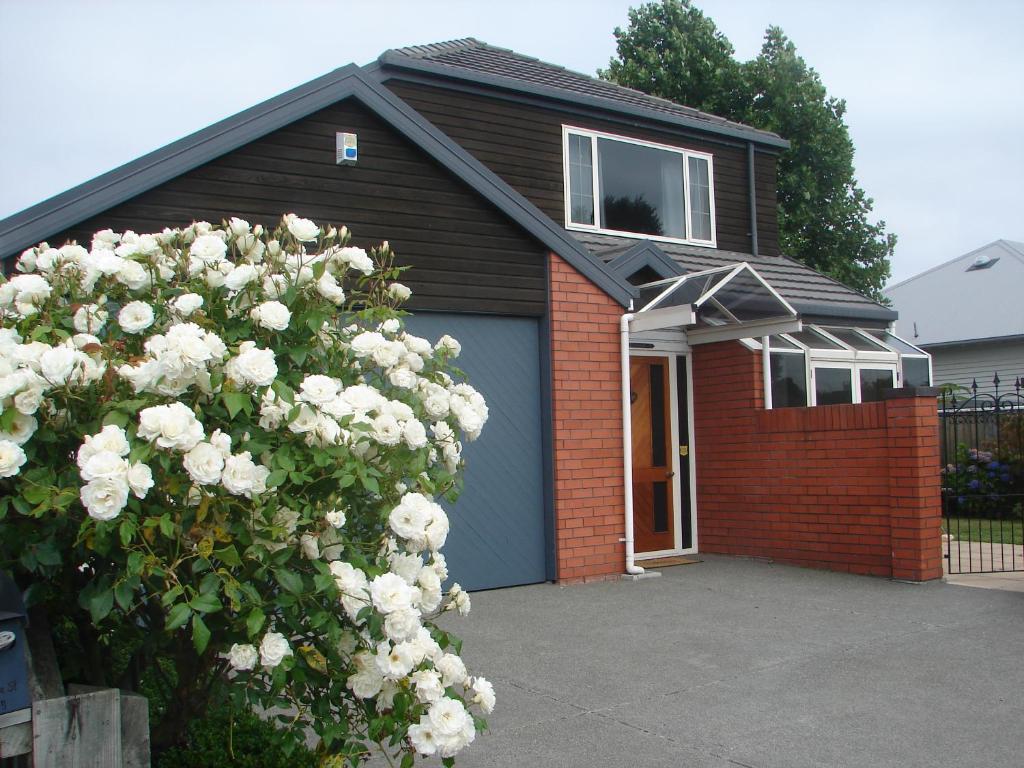 une maison avec un garage bleu avec un bouquet de roses blanches dans l'établissement Aroha Riccarton Bed and Breakfast, à Christchurch