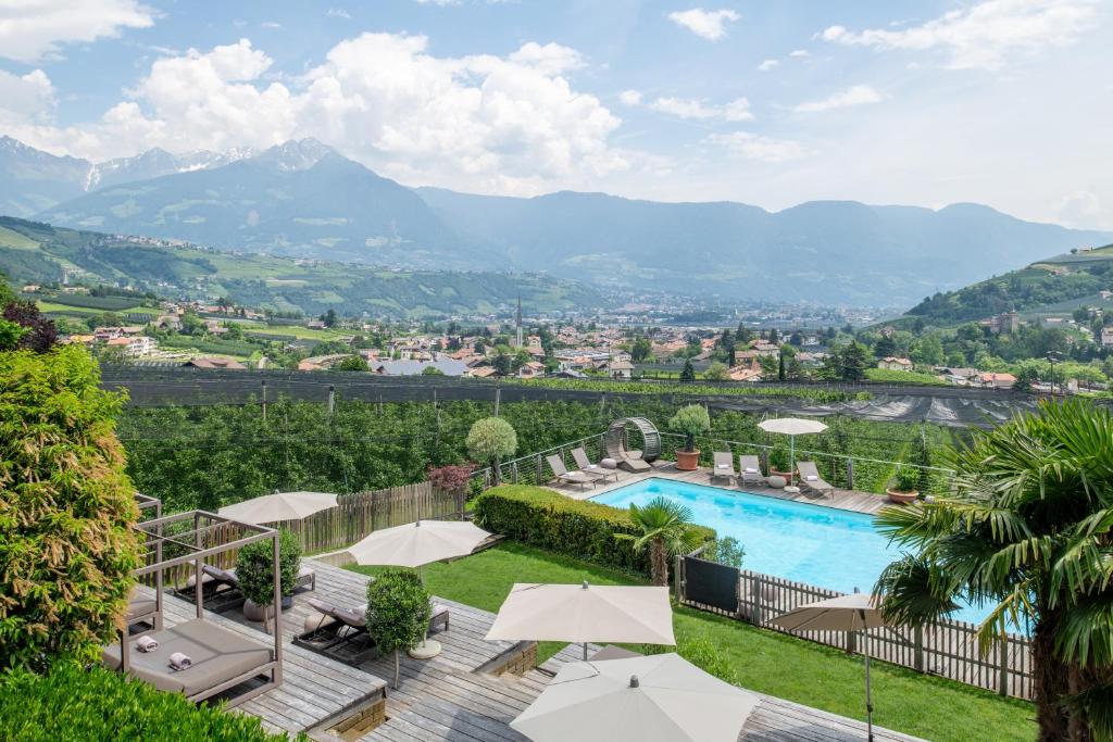 un complexe avec une piscine et des montagnes en arrière-plan dans l'établissement Hotel Residence MaVie, à Lagundo