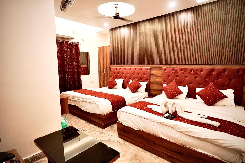 una habitación de hotel con 2 camas en una habitación en HOTEL VIA GANGA INN ! గంగా ఇన్ ద్వారా హోటల్ VARANASI! FULLY AIR-CONDITIONED HOTEL AT PRIME LOCATION WITH ROOFTOP GANGES VIEW! 2 Min walking distance from ASSI GHAT ,NEAR KASHI VISHWANATH TEMPLE, en Varanasi