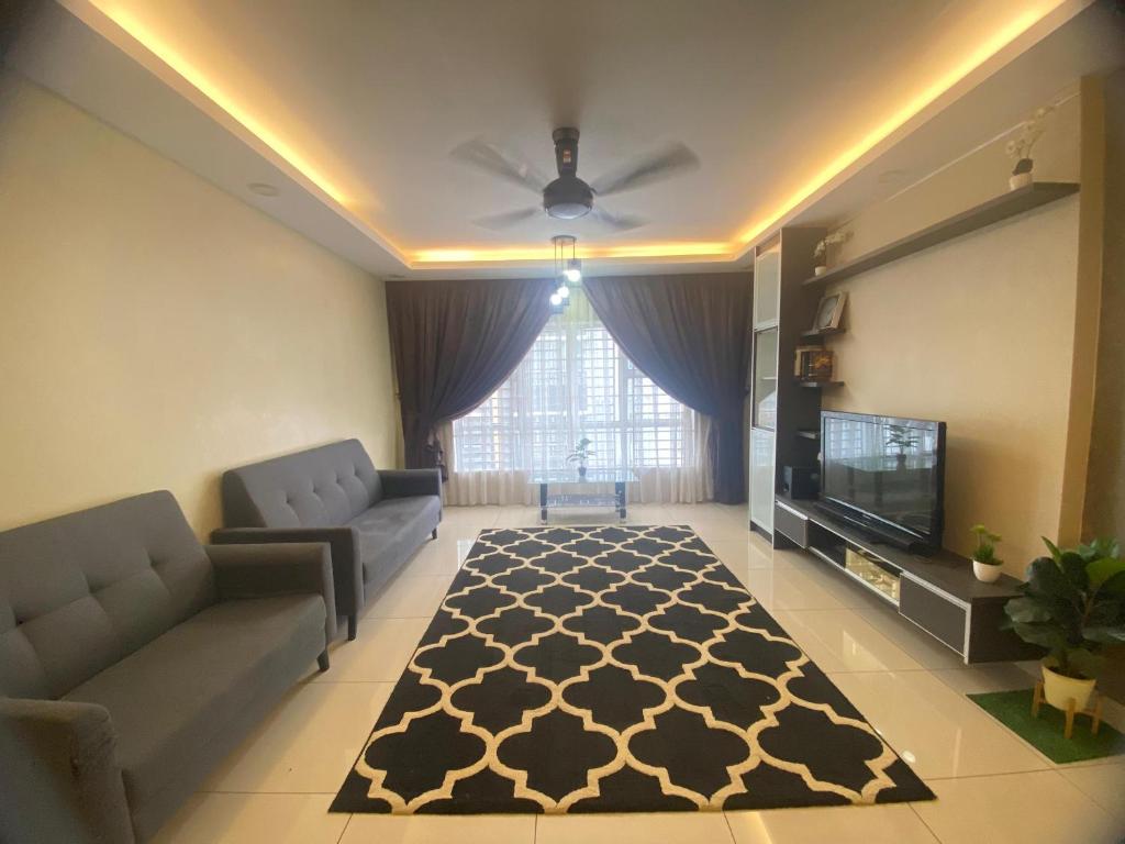 sala de estar con sofá y TV en Cozy Homestay Putrajaya, en Putrajaya