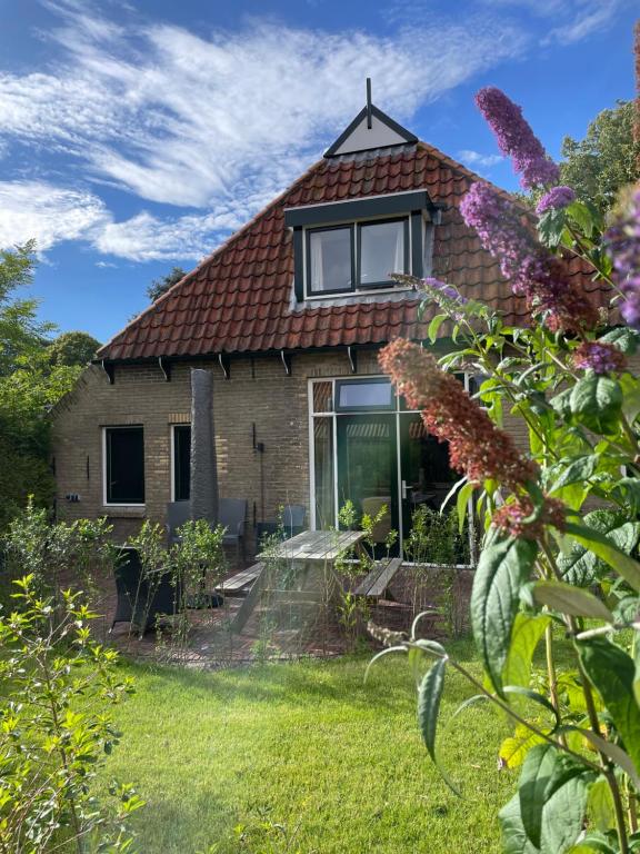 ein Haus mit Garten und ein paar Blumen in der Unterkunft Feiliche Haven Ameland in Nes