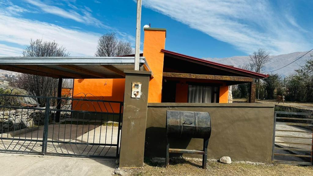 un piccolo edificio con una sedia di fronte di Casa tafi a Tafí del Valle