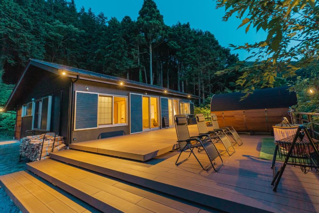 une petite maison assise sur une terrasse avec des chaises dans l'établissement moon hakone, à Hakone