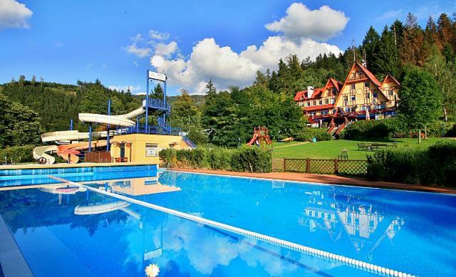 una grande piscina di fronte a una grande casa di Hotel Sluníčko a Ostravice