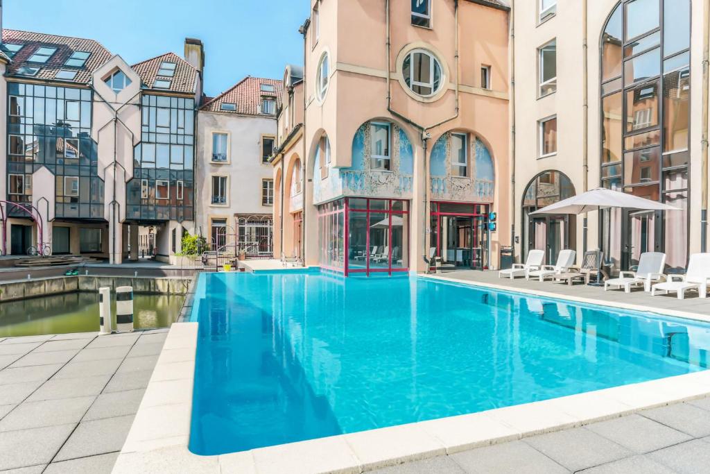 ein Schwimmbad in der Mitte eines Gebäudes in der Unterkunft Hôtel Du Théâtre Centre Historique Parking Souterrain Gratuit in Metz