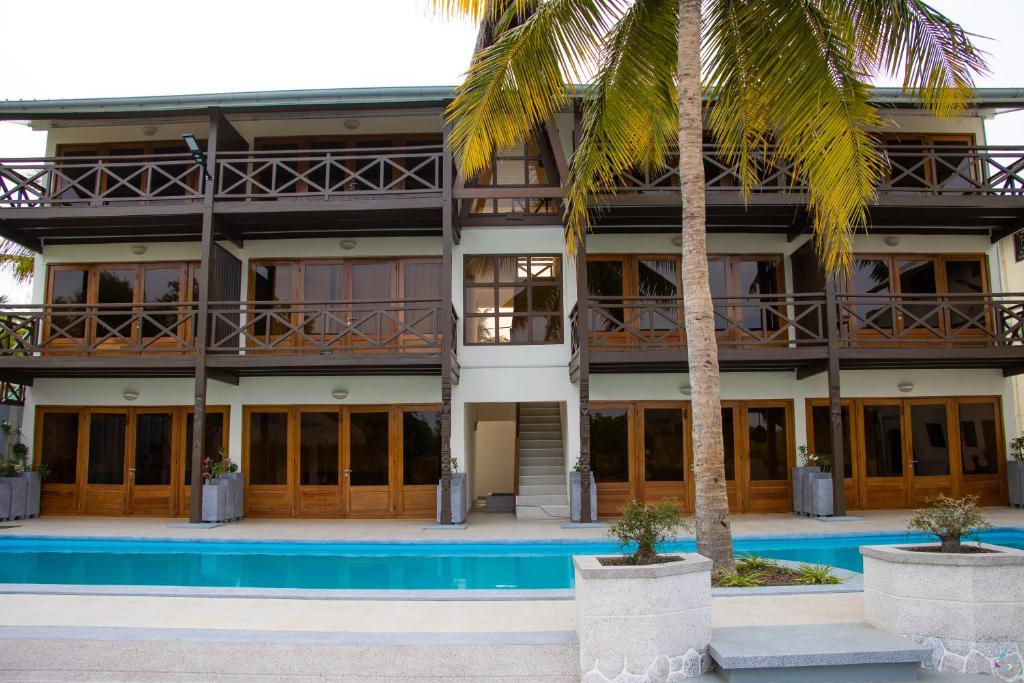 ein Gebäude mit einem Pool und Palmen in der Unterkunft Hôtel Baobab Café in Morondava