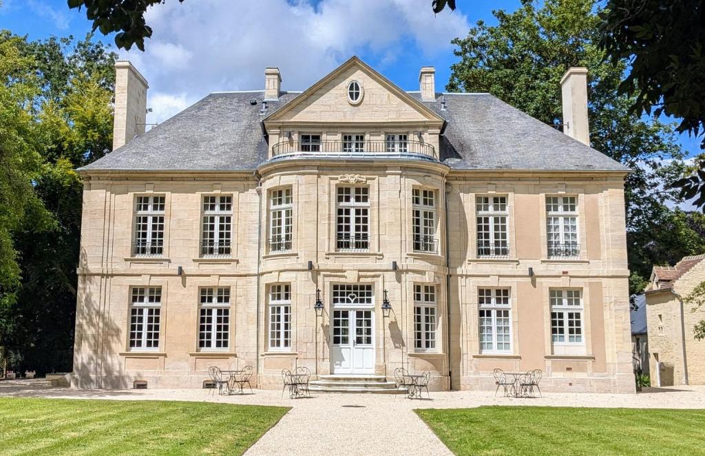 Bény-sur-MerHôtel 4 étoiles Château - Domaine de Coeurmandie的大型砖屋,设有大窗户