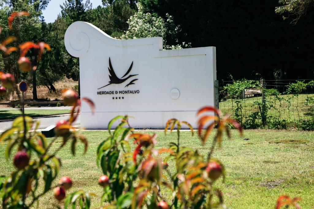 ein Schild für einen Park mit Blumen im Vordergrund in der Unterkunft Herdade de Montalvo - Comporta in Comporta