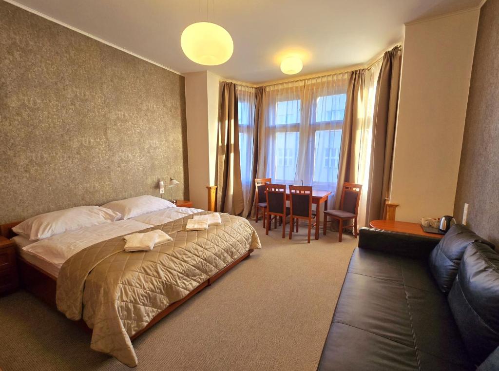 een hotelkamer met een bed en een eetkamer bij Kafka Prague rooms in Praag