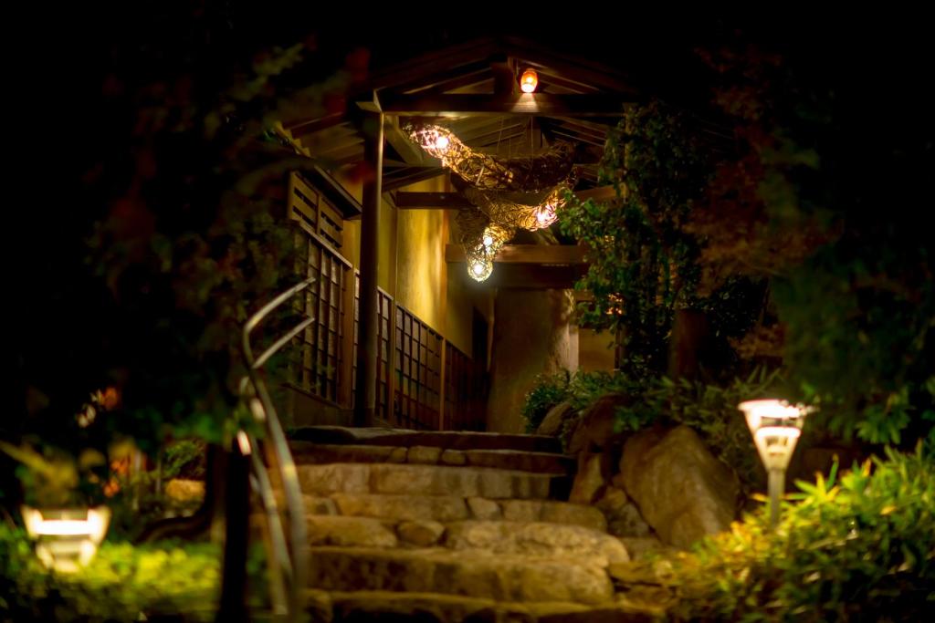 un escalier menant à une maison la nuit dans l'établissement Sennenmatsu, à Imabari