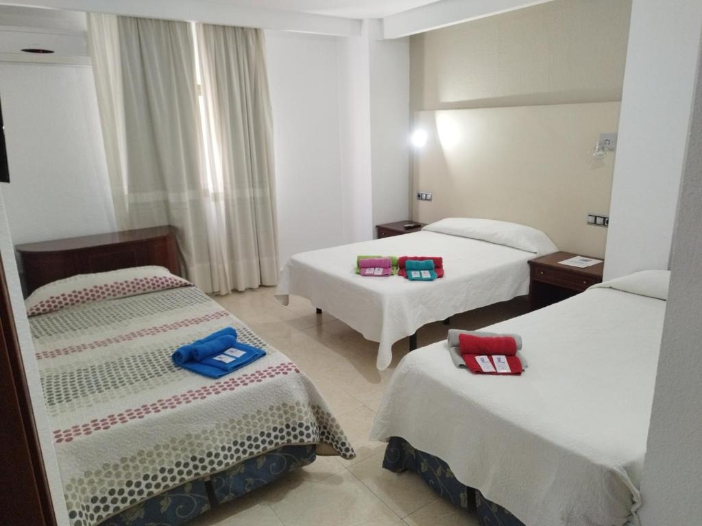 ein Hotelzimmer mit 2 Betten und Handtüchern darauf in der Unterkunft Hotel Nuevo Ara in Cáceres