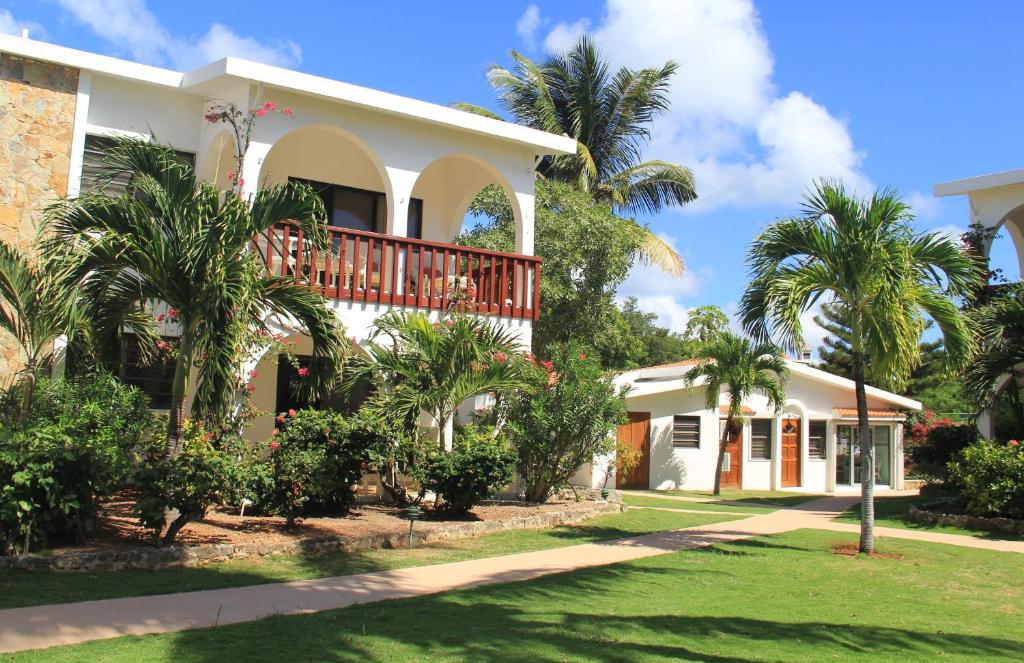 une maison avec un balcon et des palmiers dans l'établissement Carimar Beach Club, à Meads Bay