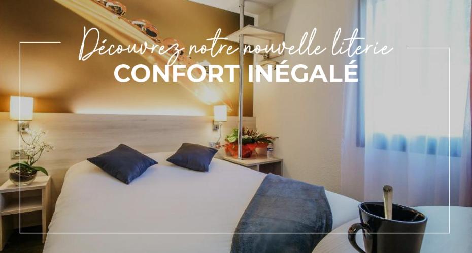 - une chambre avec un lit blanc et des oreillers bleus dans l'établissement Hôtel Inn Design - Restaurant L'Escale, à Rochefort