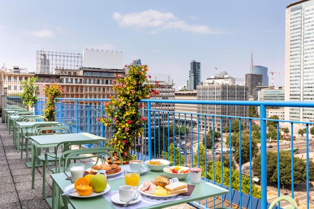 a table with plates of food on a balcony at B&B Hotel Milano Aosta in Milan