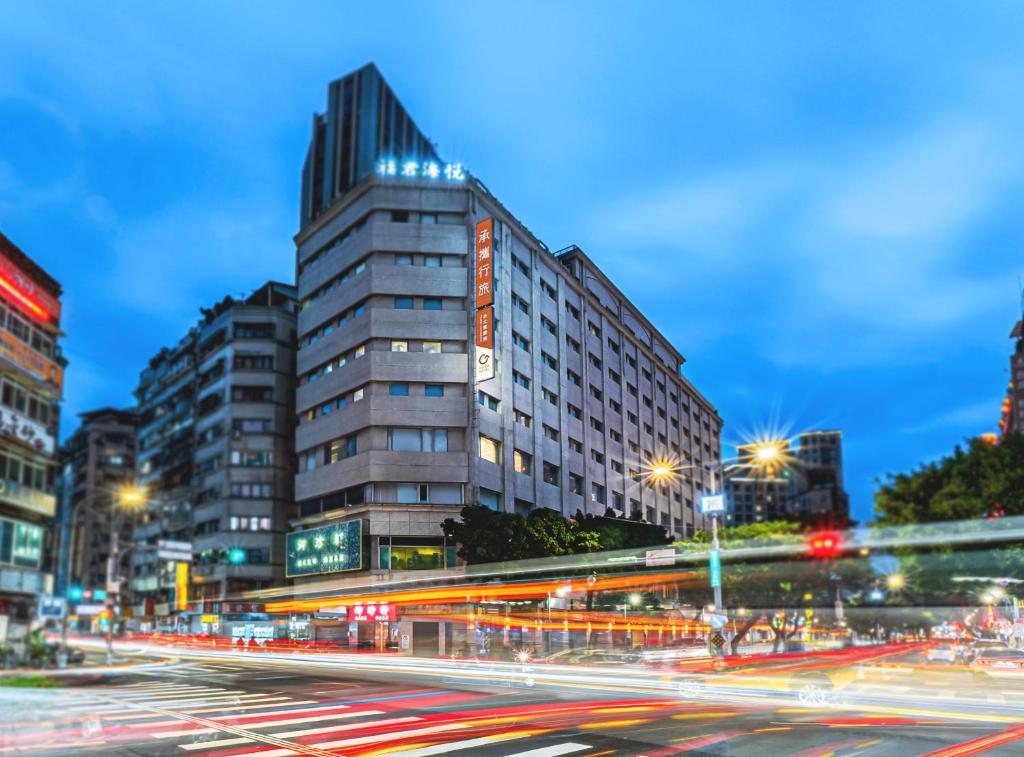 een straat met een hoog gebouw 's nachts bij Guide Hotel Taipei Chongqing in Taipei