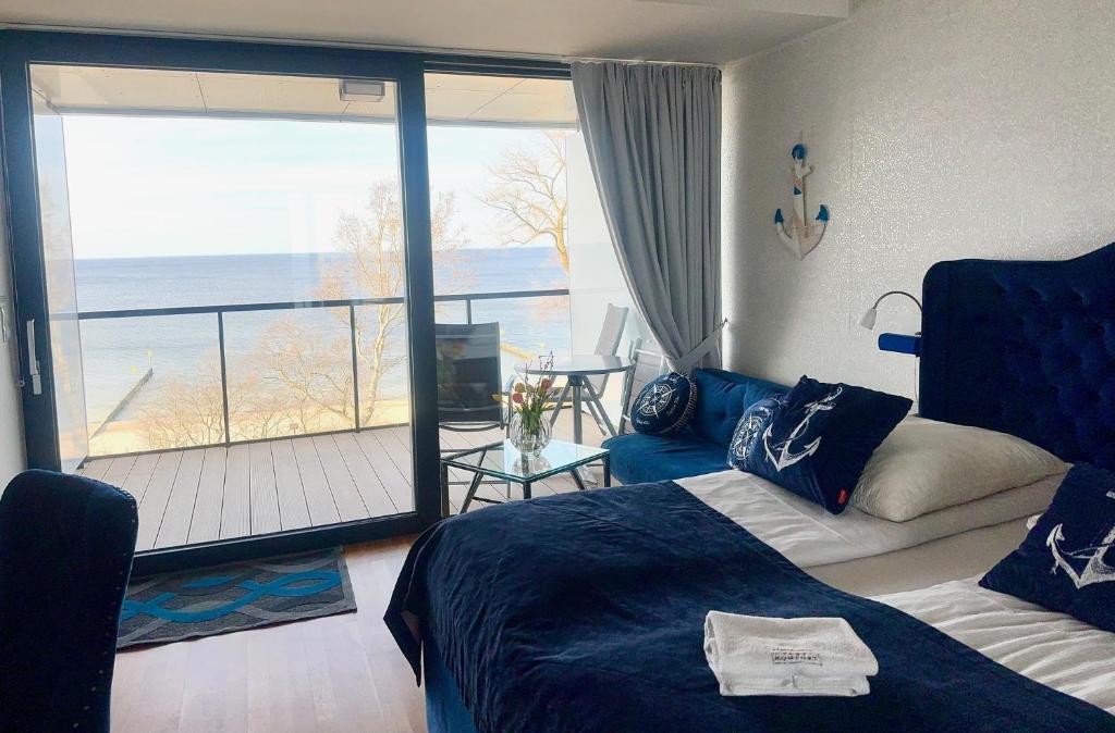 1 Schlafzimmer mit einem Bett und einem Balkon mit Aussicht in der Unterkunft Seaside - Apartamenty KOMFORT, widok na morze, Parking in Kołobrzeg