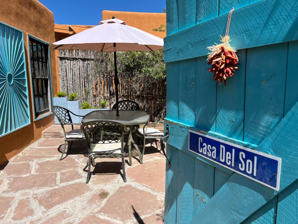 un edificio azul con una mesa y una sombrilla en Casa Del Sol, en Santa Fe