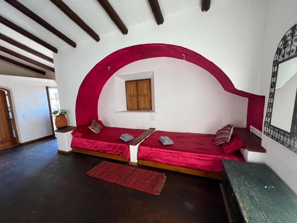 a bedroom with a red bed in a room at Monte novo in Odeceixe