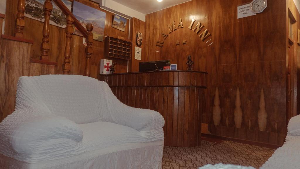 a living room with a white chair and a counter at Rama Inn Hostal in Puno