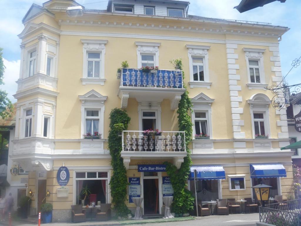 a yellow building with a balcony on a street at Nannerls Penthouse in Sankt Gilgen