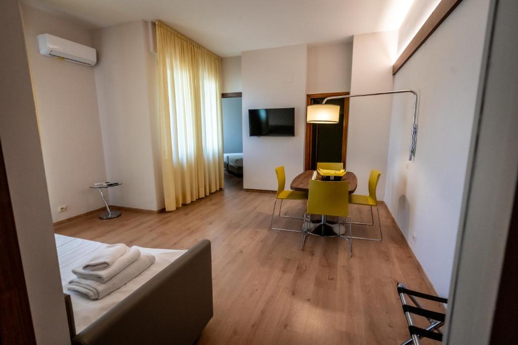 una camera d'albergo con letto, tavolo e sedie di Residence Porta Al Prato a Firenze