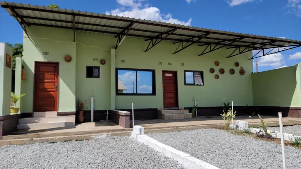 Casa verde con puertas y ventanas de madera en Mew3 Apartment, en Ndola