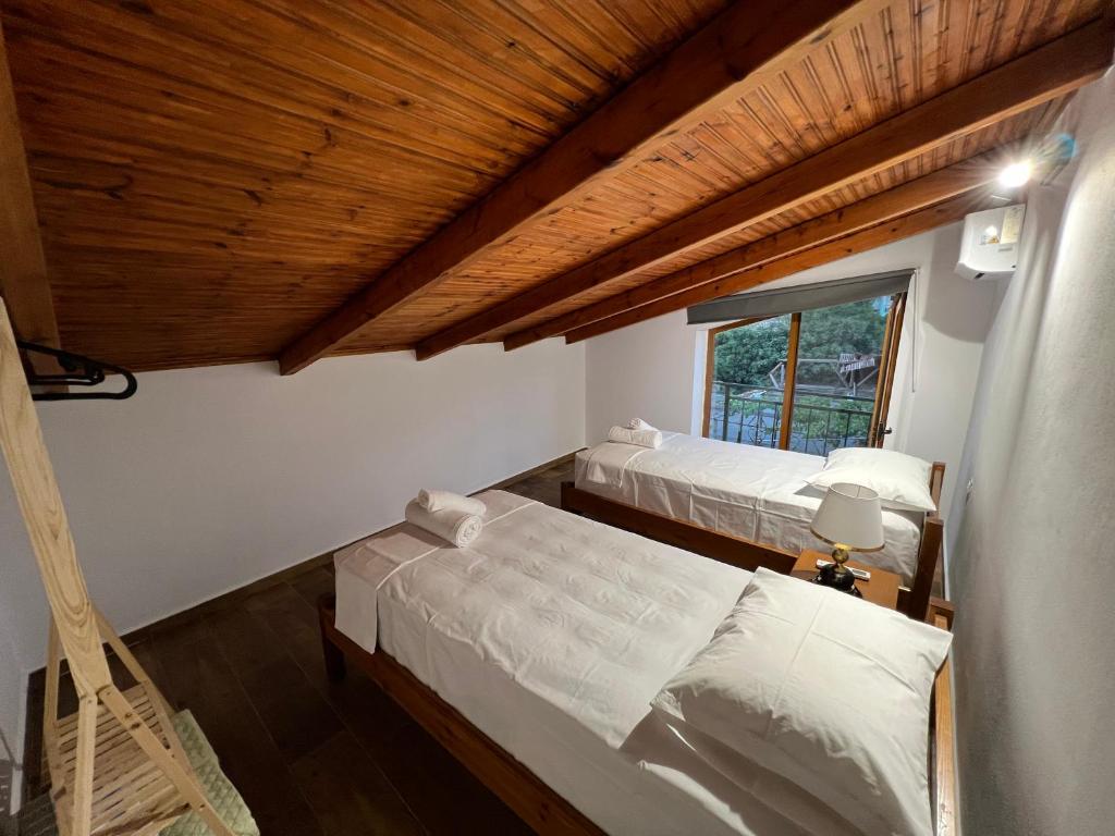 Duas camas num quarto com tecto em madeira em Sajmir Suites em Përmet