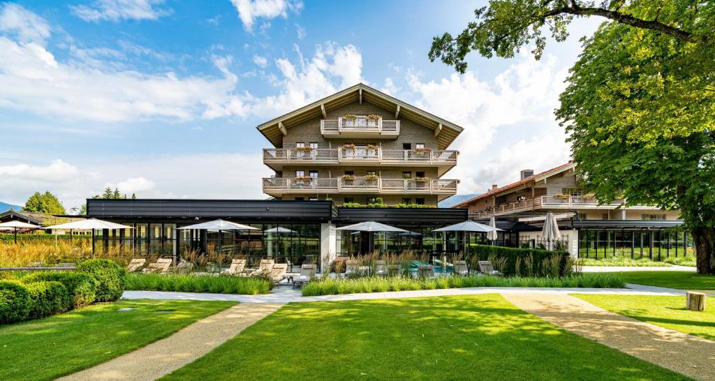 un hôtel avec une pelouse devant un bâtiment dans l'établissement Parkhotel Egerner Höfe, à Rottach-Egern