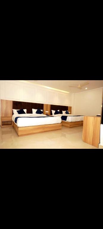 two beds in a large room with at Hotel Midway Inn in Amritsar