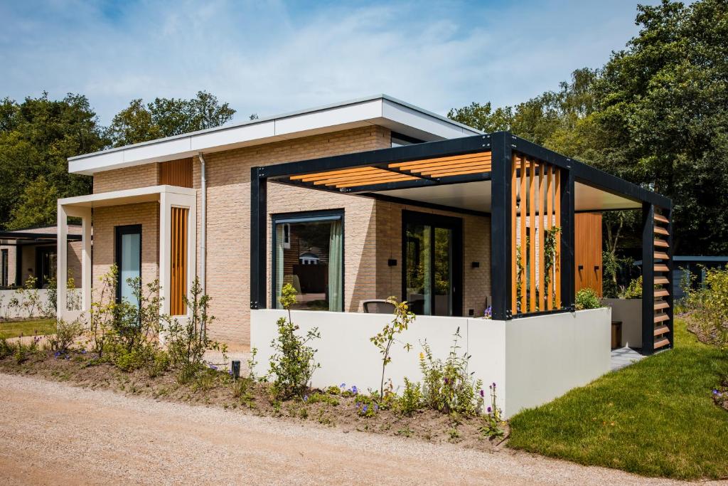 a brick house with a black frame at Recreatiewoning 'Steenpatrijs' in Voorthuizen