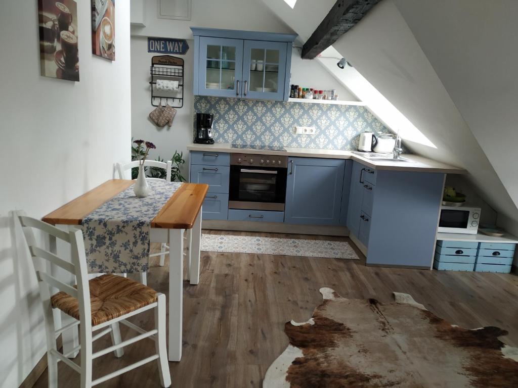 a kitchen with blue cabinets and a wooden table at Ferienwohnung Luna in Trier