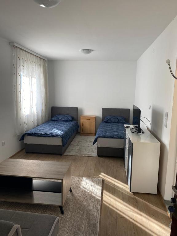 ein Wohnzimmer mit 2 Betten und einem Tisch in der Unterkunft Rooms Lepara in Konjic