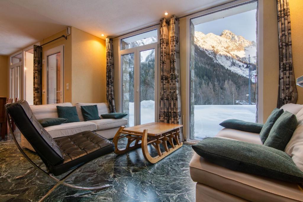 Chalet Glacier - Happy Rentals في شامونيه مون بلان: غرفة معيشة بها كنب ونافذة كبيرة