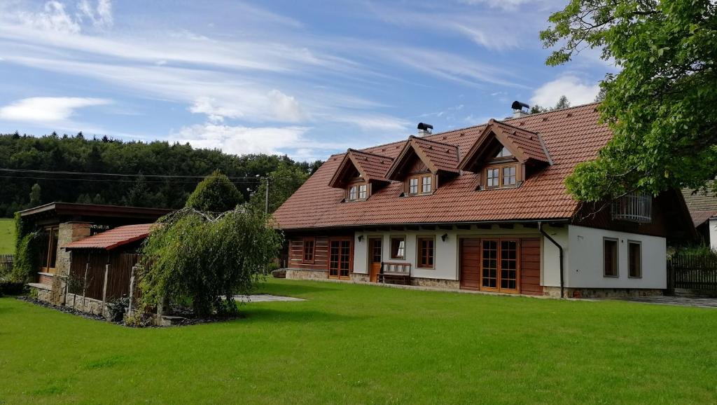 une maison avec une cour verdoyante devant elle dans l'établissement Roubenka Poldovka, à Volfířov