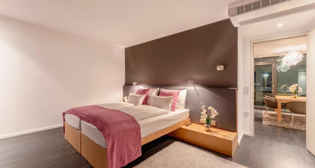 1 Schlafzimmer mit einem großen Bett und einem Badezimmer in der Unterkunft PLAZA INN Graz in Graz