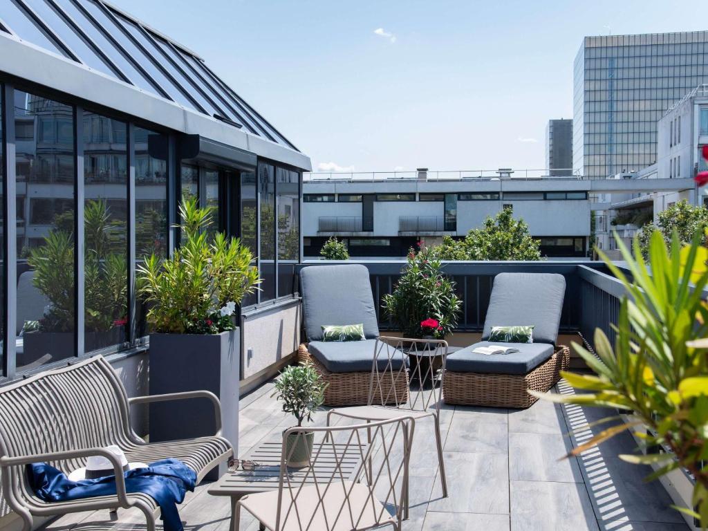 uma varanda com cadeiras e plantas num edifício em Mercure Paris Bercy Bibliothèque em Paris