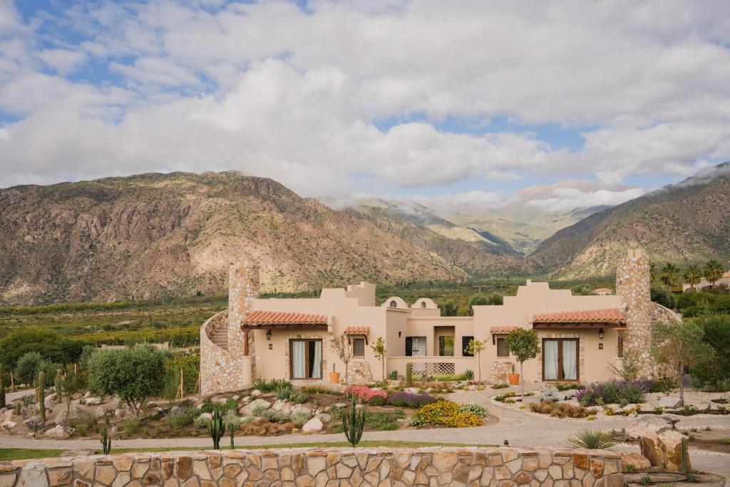 uma casa grande com montanhas ao fundo em Piattelli Wine Resort Hotel Cafayate em Cafayate