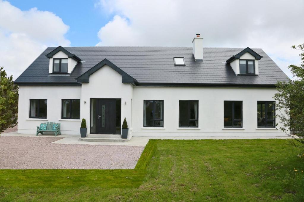 Biały dom z czarnym dachem w obiekcie Luxury 6 Bedroom Spiddal Villa, Jacuzzi, Balcony w Galway