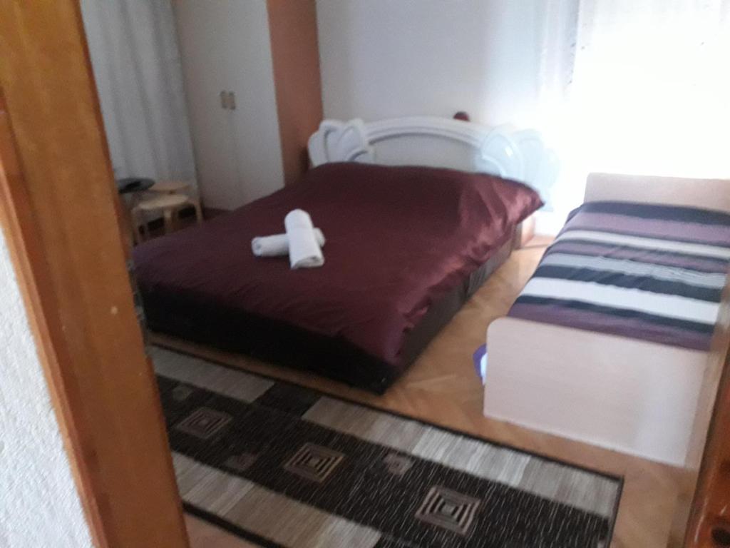 Rooms Struga في ستروغا: غرفة نوم صغيرة مع سرير عليه غرض أبيض