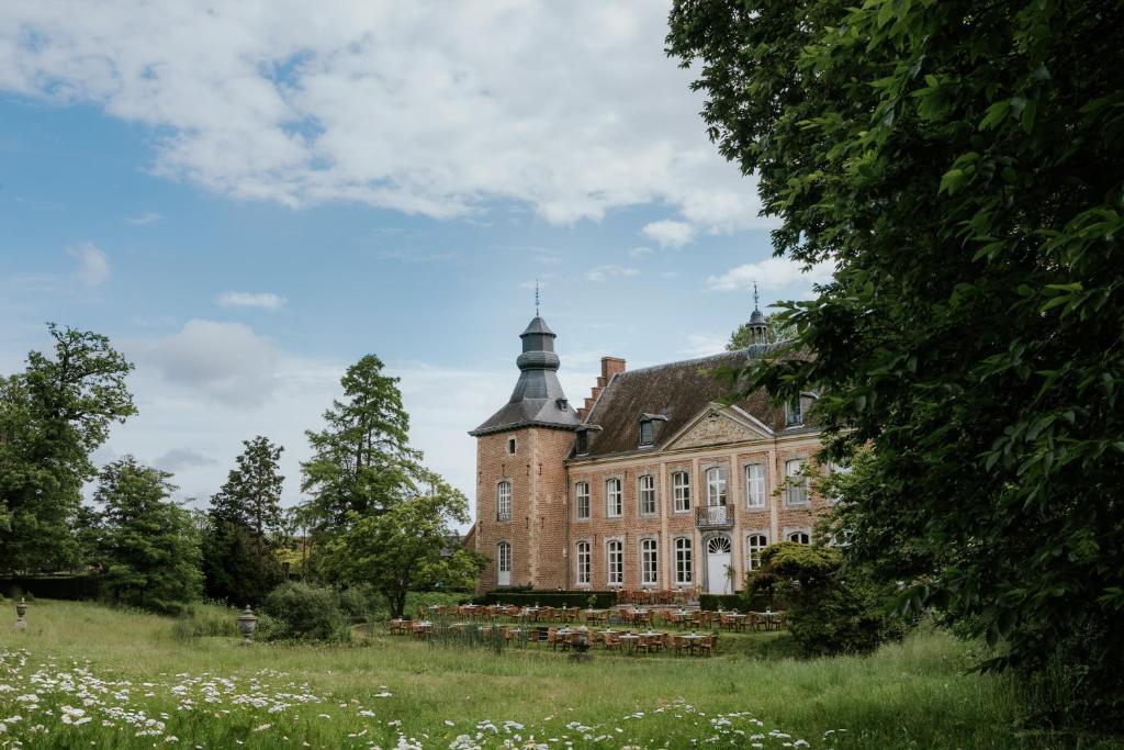 stary ceglany budynek z wieżą na szczycie pola w obiekcie Château de Looz w mieście Borgloon