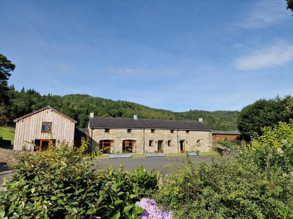 stary kamienny budynek z czarnym dachem w obiekcie Tyddyn at Hendre Rhys Gethin w mieście Betws-y-coed