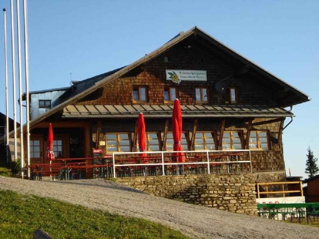 un edificio con ombrelli rossi di fronte di Arberschutzhaus a Bayerisch Eisenstein