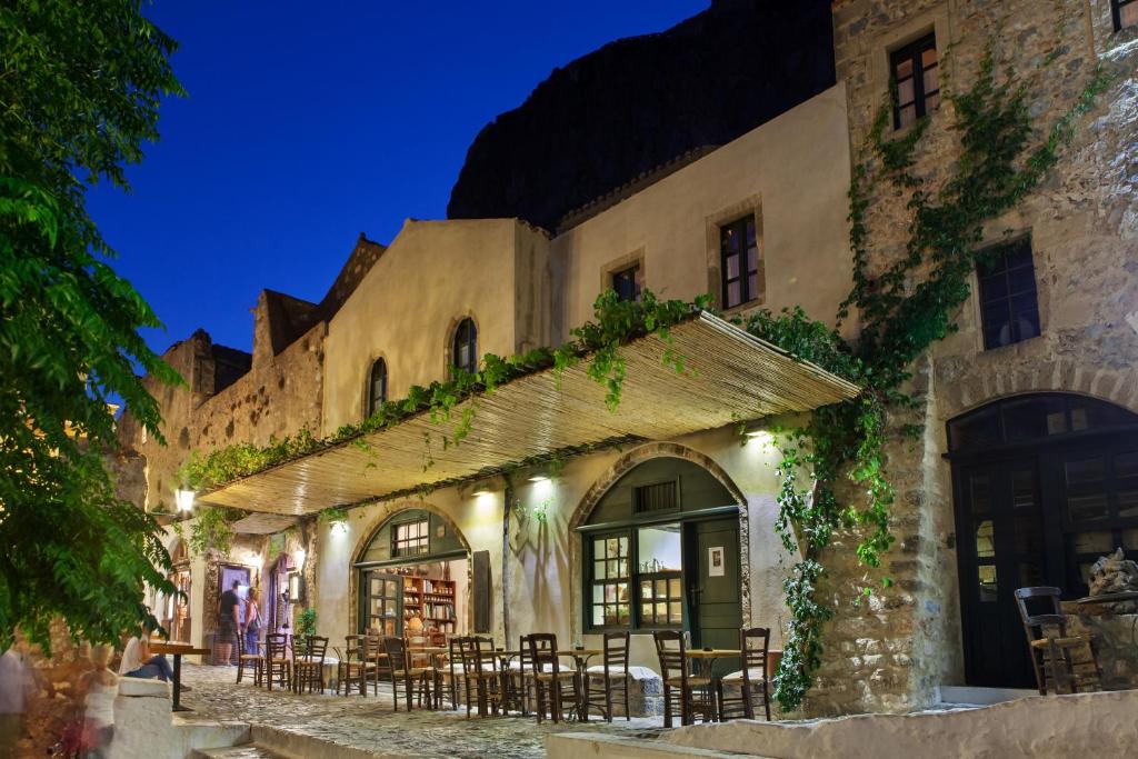 un bâtiment avec des tables et des chaises à l'extérieur la nuit dans l'établissement Byzantino Boutique Hotel, à Monemvasia