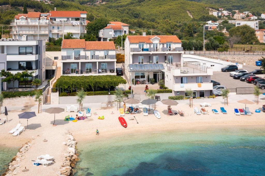 una vista aerea su una spiaggia con sedie e ombrelloni di Seaside Luxury Suites a Podstrana