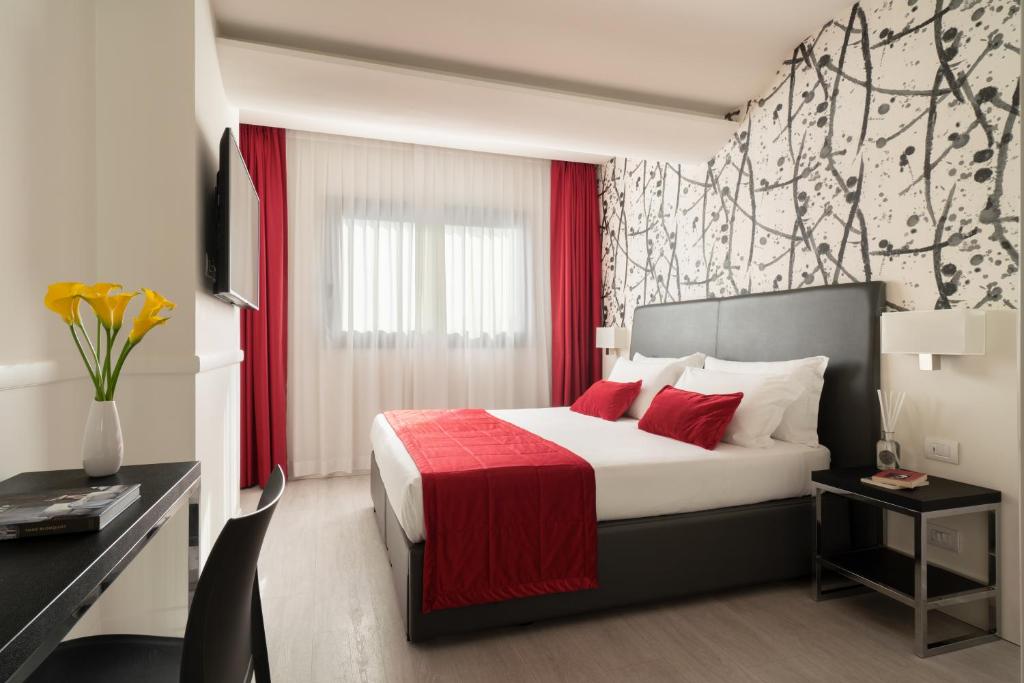 a hotel room with a bed with a red blanket at Hotel American Palace Eur in Rome