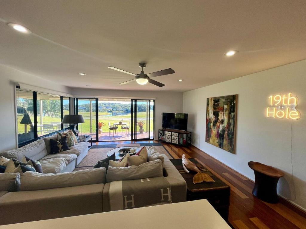 ein Wohnzimmer mit einem Sofa und einem Deckenventilator in der Unterkunft Perfect weekend getaway plus golf at your doorstep in Salamander Bay