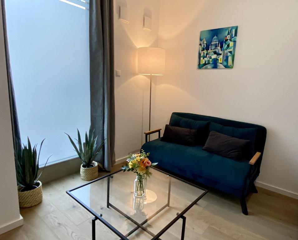 a living room with a blue couch and a glass table at Apartment am Lutherplatz in Potsdam