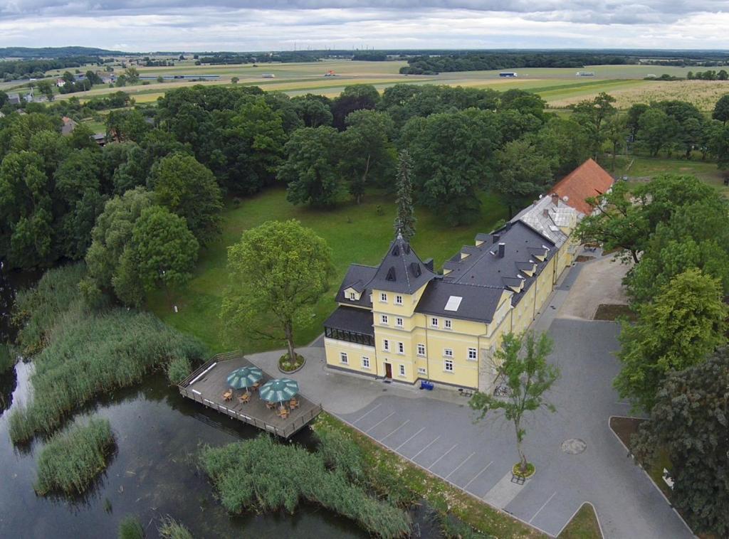 een luchtzicht op een groot geel gebouw met een zwart dak bij Pałac Lucja BB in Zakrzów