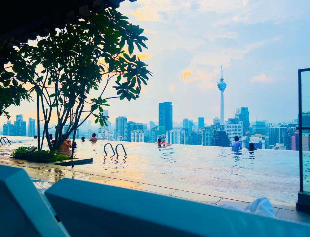 uma piscina com um horizonte urbano ao fundo em Axon Residence KLCC - KL HOME em Kuala Lumpur